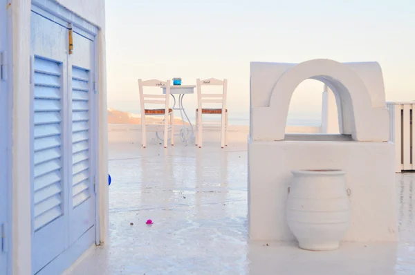 Chaises sur terrasse blanche dans une maison sur l'île de Santorin — Photo