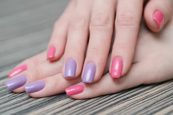 Las manos de las mujeres con un esmalte de uñas de color — Foto de Stock