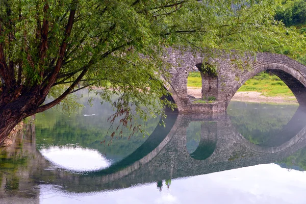 Ponte arqueada refletida no rio Crnojevica, Montenegro, Balcãs — Fotografia de Stock