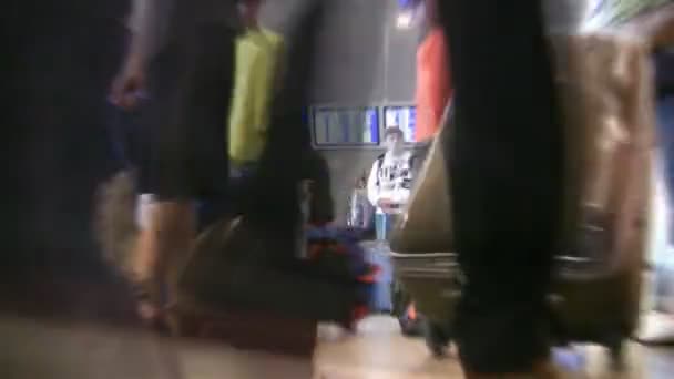 Пассажиры с багажом в зале аэропорта — стоковое видео