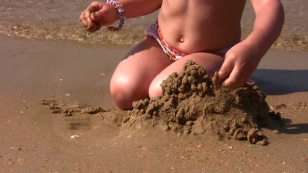 Hands of little girl play with sand on beach — Stock Video