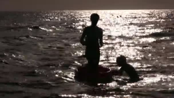 Silhueta mãe com crianças na água — Vídeo de Stock