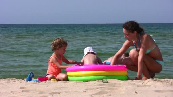 Madre con bambini gioca in spiaggia — Video Stock