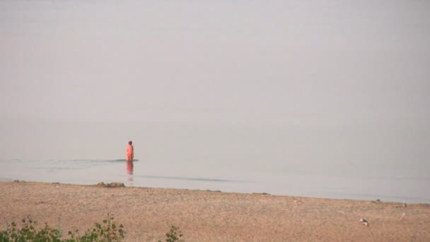 Один пенсионер плавает на пляже — стоковое видео