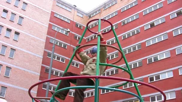 Junge klettern auf Spielplatz — Stockvideo