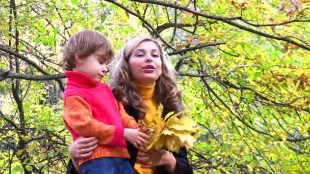 Мать с детьми в осеннем парке. — стоковое видео