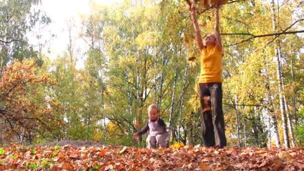 Mère avec des feuilles de lancer d'enfant — Video