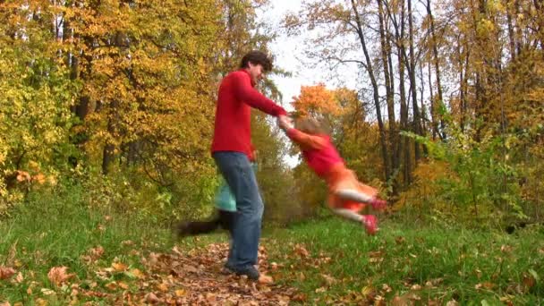 Père tourner deux enfants dans le parc d'automne 