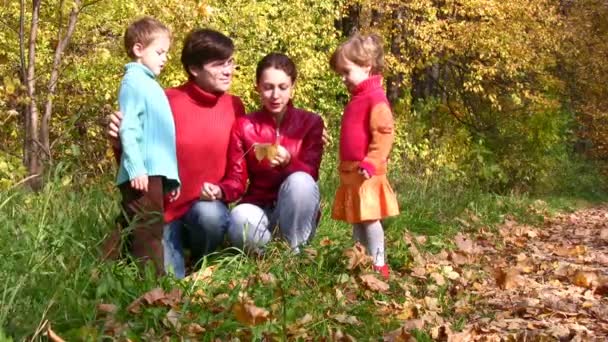 Familie van vier verkennen iets in herfst park — Stockvideo