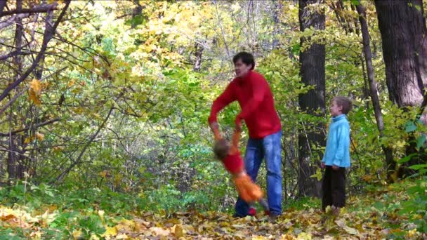 Padre jugar con dos niños en el parque de otoño . — Vídeo de stock