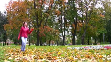 sonbahar Park yaprakları atan kadın