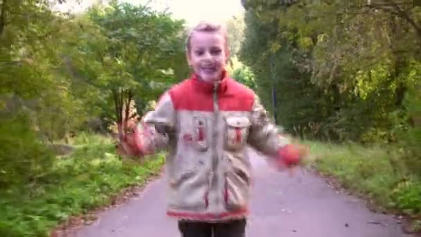 Enfant en course dans le parc automnal — Video