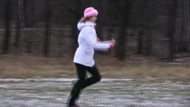 Женщина бегает по лесу с первым снегом . — стоковое видео