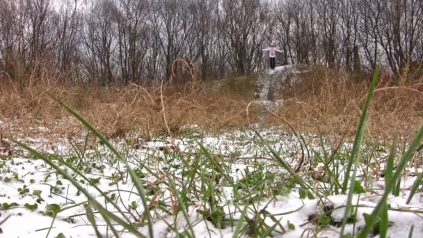 Бегущая женщина. Трава под снегом . — стоковое видео