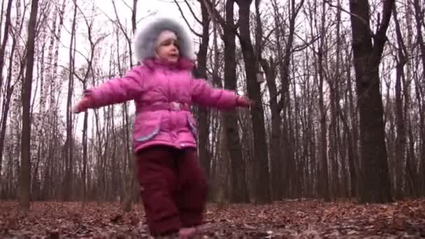 Маленькая девочка вращается в зимнем парке — стоковое видео