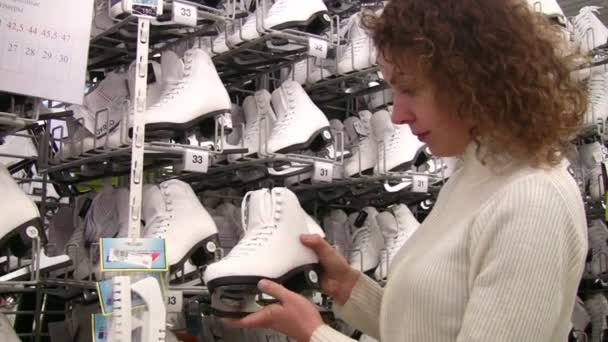 Vrouw kijken schaatsen in winkel — Stockvideo