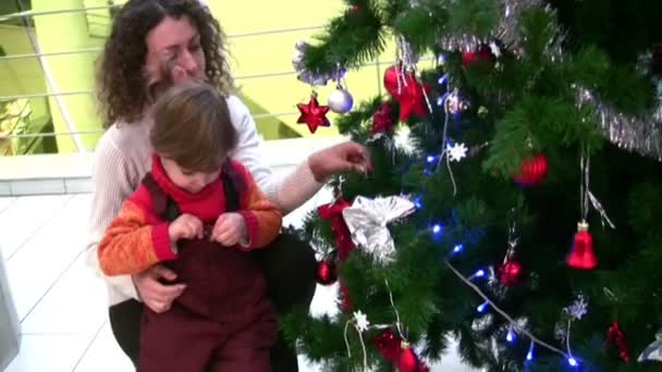 お店のクリスマス ツリーを見ている小さな女の子の母 — ストック動画