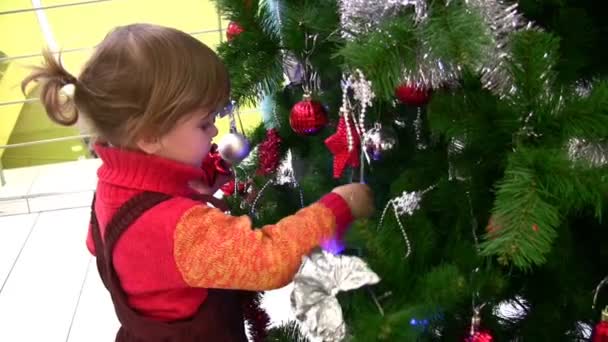 Petite fille regardant arbre de Noël dans le magasin 