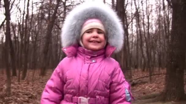 Ходячая девочка в зимнем парке на камеру — стоковое видео