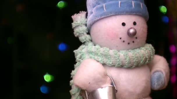 Juguete de muñeco de nieve girando cerca del árbol de Navidad — Vídeo de stock