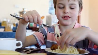 Çocuk erişte yiyor.