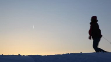 siluet anne çocuk kızağa taşır.