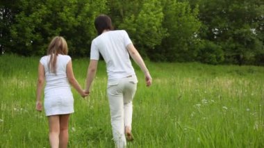 genç adam ve kız tutuşup walking away