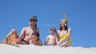 kum üzerine oturan yüzücüler, mutlu bir aile