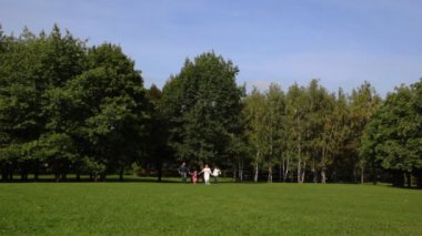 Aile ile erkek ve kız için ellerini tutarak geri park üzerinde çalışır