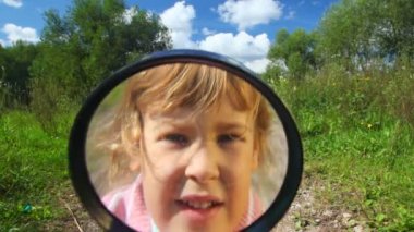 küçük kız, kamera bir büyüteç görünüyor