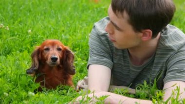 adam köpek ile konuşurken yeşil çim üzerinde yalan