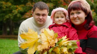 Sonbahar ile üç kişinin aile parkında yapraklar