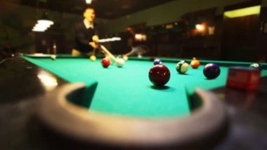 adam Bilardo kırmızı topu cebine atıyor.