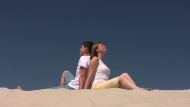 Paar sitzt auf dem Sand — Stockvideo