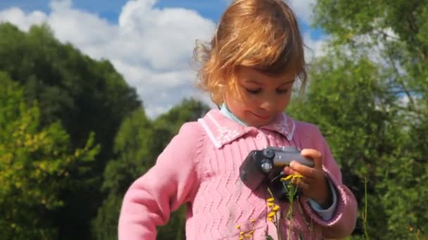 Little girl with photo camera in park — Stock Video