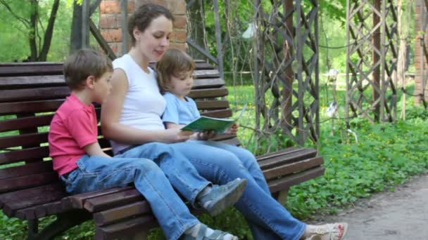 Мать читает книгу с детьми — стоковое видео