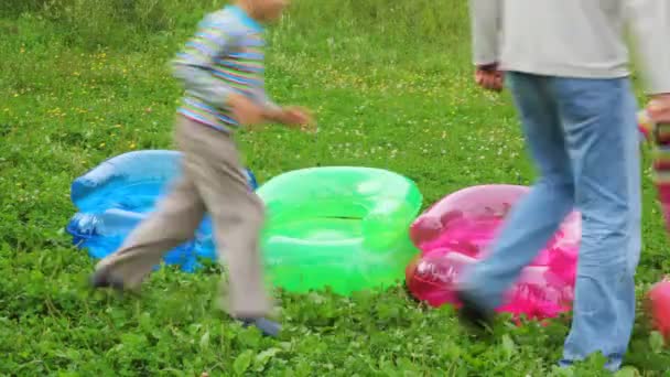 Familie rennt um aufblasbare Sessel — Stockvideo