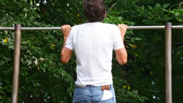 Hombre haciendo pullups en el parque — Vídeo de stock