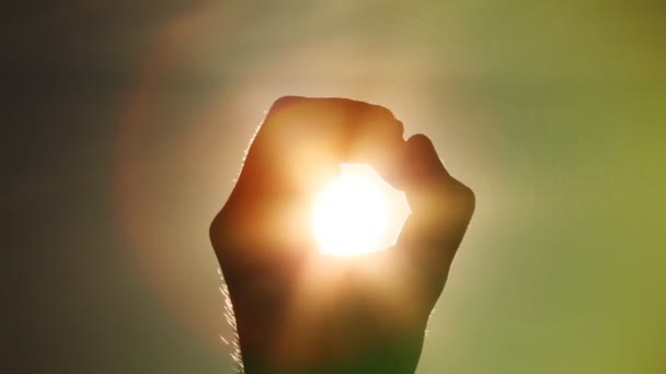 La mano sostiene el sol en un puño — Vídeos de Stock