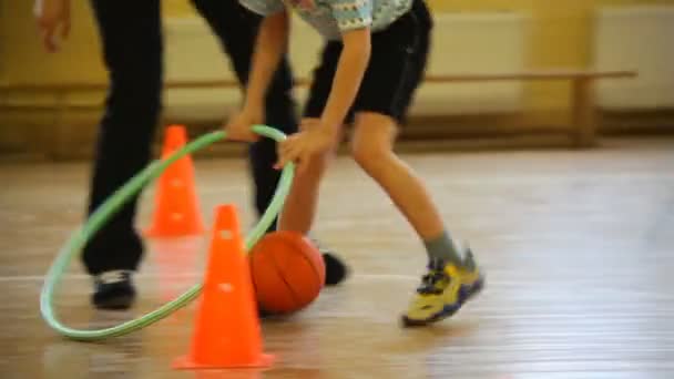 Boy rolling a ball by hoop — Stock Video