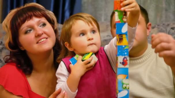 Родители и дочь играют в кубики — стоковое видео