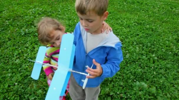 Little girl and boy playing with toy aircraft — Stock Video