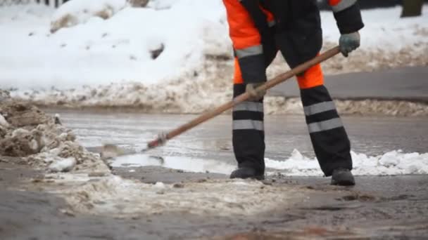 Service man with shovel on winter street — Stock Video