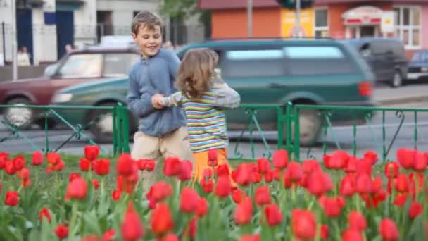 Niño y niña juegan en la calle — Vídeo de stock