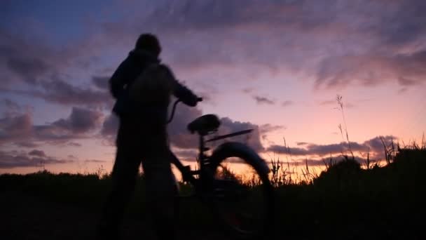 Mann und Junge mit Fahrrädern blicken auf den Sonnenuntergang — Stockvideo