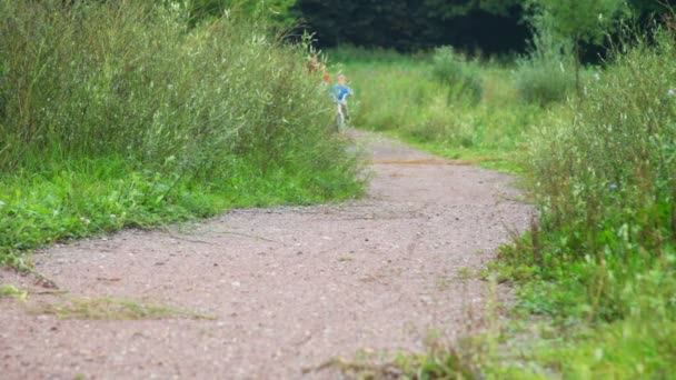 Garçon et homme à vélo dans le parc, à la caméra 