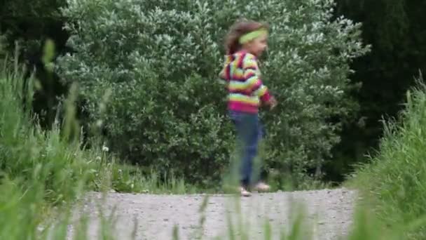 Klein meisje loopt van links naar rechts en naar achteren meerdere malen — Stockvideo