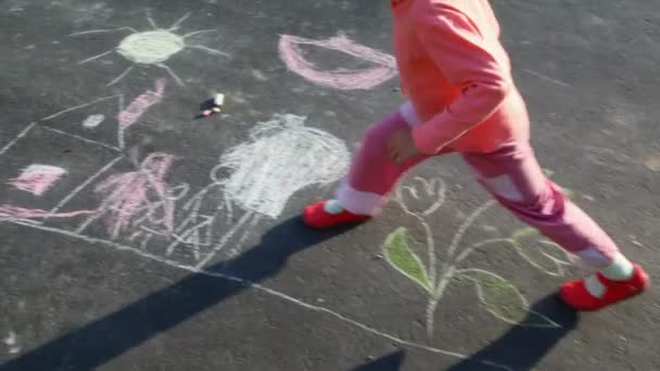 Niña caminando sobre dibujo sobre asfalto — Vídeo de stock