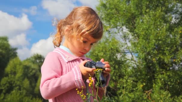 Маленька дівчинка з фотоапаратом на відкритому повітрі — стокове відео