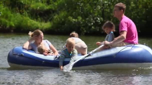 Family with 4 kids in rubber boat, rowing — Stock Video